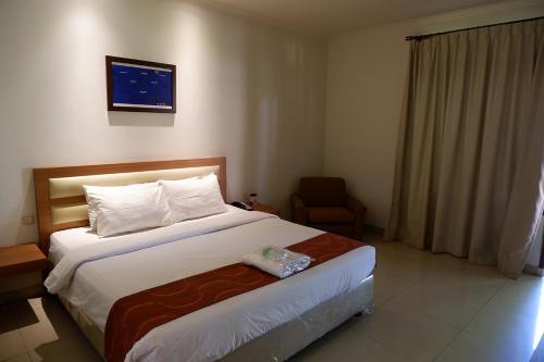 a hotel room with a bed and a chair at Sanghyang Indah Spa Resort in Anyer
