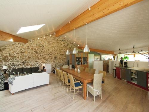 a dining room and kitchen with a table and chairs at Very nice cottage with studio on a domain with heated pool in Roussines