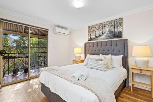 a bedroom with a large white bed with two lamps at The Bishops Escape A Sepal Stay in Perth