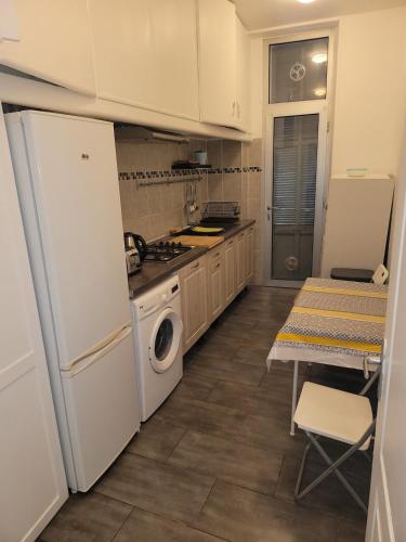 une cuisine avec un réfrigérateur blanc et une table dans l'établissement le reformé pour 6 personnes, à Marseille