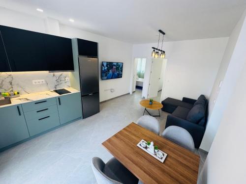 a kitchen and a living room with a couch and a table at Calpe apartamento LuXurY nuevo playa centrico parking wifi aire piscina patio in Calpe
