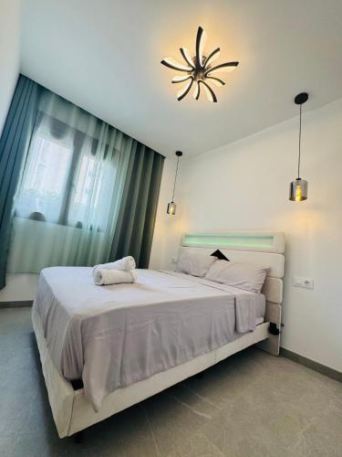 a bedroom with a large bed and a chandelier at Calpe apartamento LuXurY nuevo playa centrico parking wifi aire piscina patio in Calpe