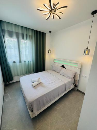 a bedroom with a large white bed with a chandelier at Calpe apartamento LuXurY nuevo playa centrico parking wifi aire piscina patio in Calpe