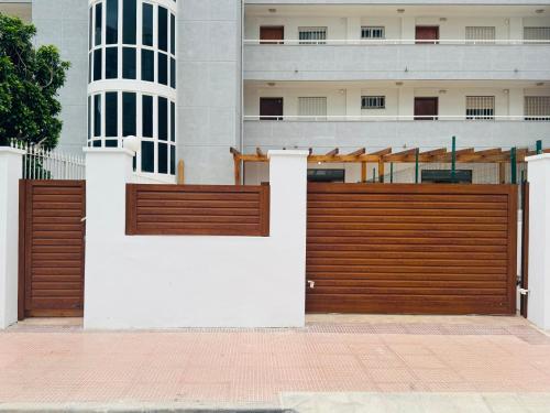 a wooden fence in front of a building at Calpe apartamento LuXurY nuevo playa centrico parking wifi aire piscina patio in Calpe