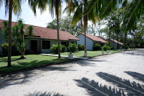 a house with palm trees on the side of a road at Sanghyang Indah Spa Resort in Anyer