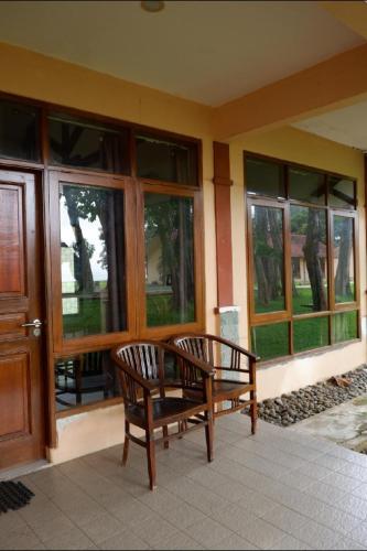 a porch with a wooden bench and windows at Sanghyang Indah Spa Resort in Anyer