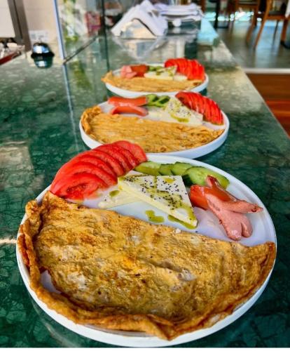 a table with three plates of food on it at Arbo Boutique Hotel in Durrës
