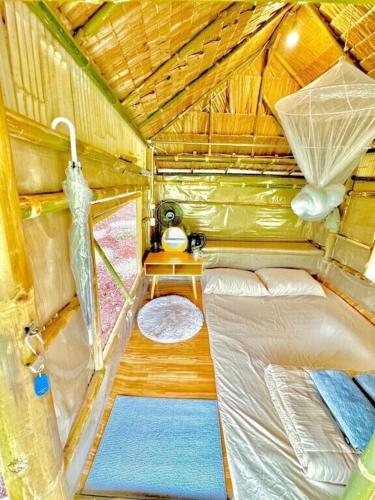 a small room with a bed and a window at บ้านไม่ไผ่บ้านเวร-BambooHouse Banwen in Ban Khun Nam Nan