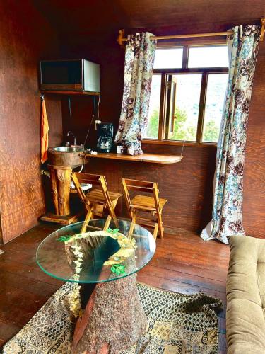a living room with a glass table and a window at Trini Treehouse By GEstores in Huasca de Ocampo
