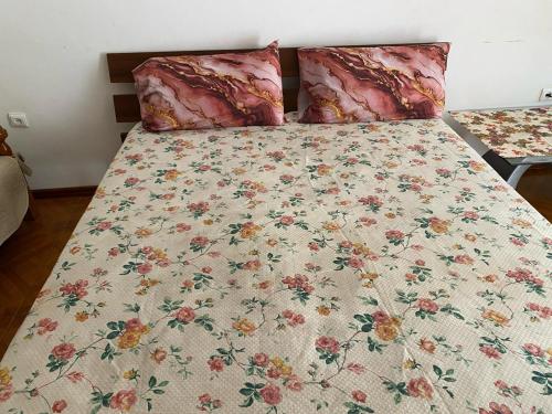 un letto con un piumone floreale e due cuscini di Apartamento em Monte a Mindelo