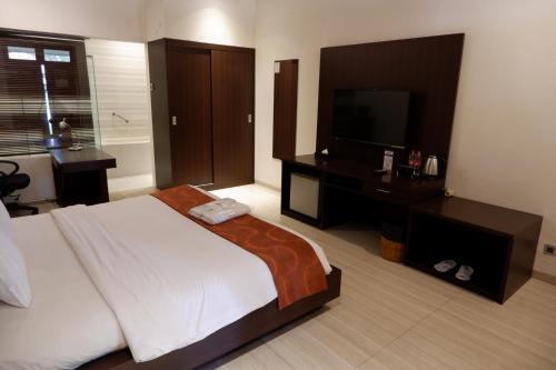 a bedroom with a large bed and a television at Sanghyang Indah Spa Resort in Anyer