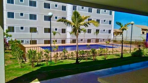 a building with a swimming pool in front of a building at APP 2 Quartos Belle Nature in Valparaíso de Goiás