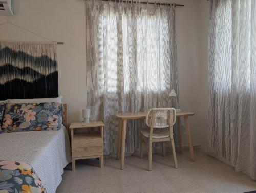 a bedroom with a table and a bed and a window at Explorers Fortuna Studio in Luquillo