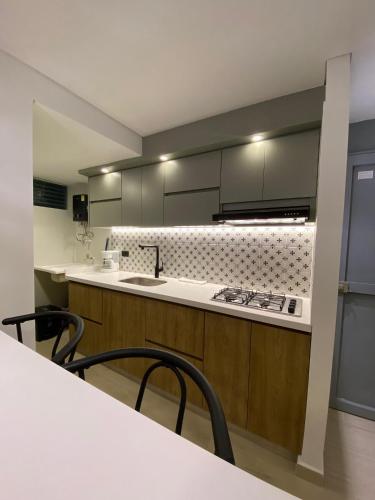 a kitchen with a sink and a counter with chairs at Apartamento Vacacional in Armenia