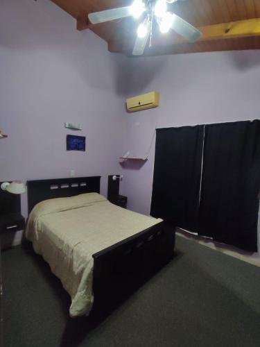 a bedroom with a bed and a ceiling fan at Casa amplia y moderna in Eldorado