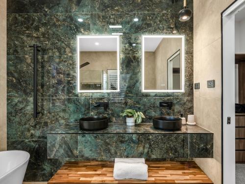 a bathroom with two sinks and a mirror at Coastal Dream BeachFront Oasis in Newcastle
