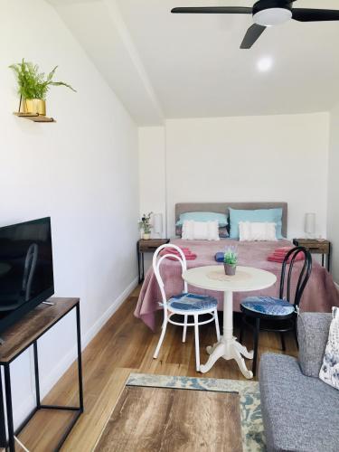 a living room with a bed and a table and chairs at The Blue Wren free wifi in Branxton