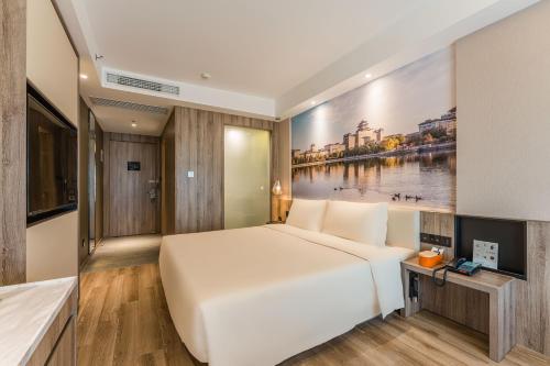 a bedroom with a large bed and a painting on the wall at Atour Hotel Beijing Zhongguancun Life Science Park in Yongfengtun