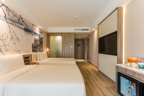 a hotel room with a large bed and a flat screen tv at Atour Hotel Beijing Zhongguancun Life Science Park in Yongfengtun