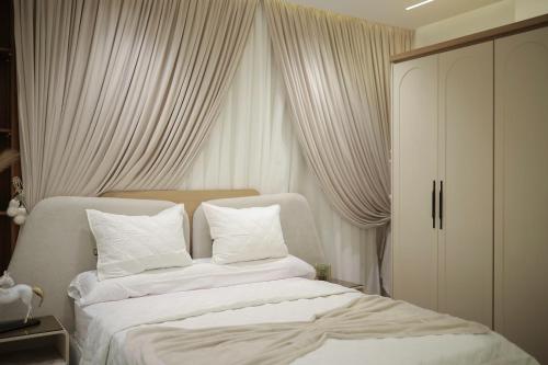 a bedroom with two white beds with white curtains at شقة فندقية المنصوره شارع الجلاء الرئيسي امام بوابة جامعة المنصورة in Mansoura