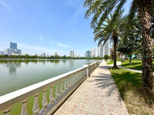 a sidewalk next to a body of water with buildings at Lux Studio Apt In Vinhomes Convenient To Airport in Hanoi