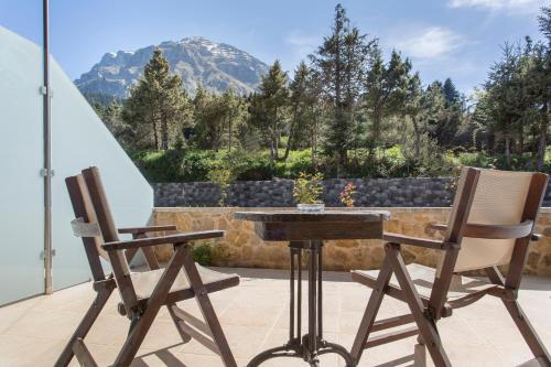 two chairs and a table on a patio with a mountain at Orizontes Tzoumerkon Hotel Resort in Pramanta