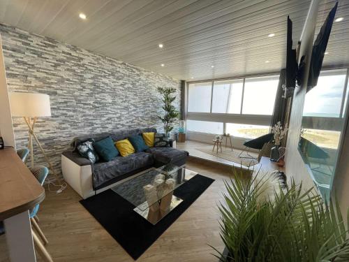 un salon avec un canapé et un mur de briques dans l'établissement Appartement moderne 2 pièces avec parking à Saint-Jean-de-Monts - FR-1-224C-352, à Saint-Jean-de-Monts