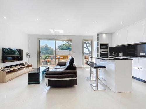 une grande cuisine blanche avec un canapé et une table dans l'établissement Appartement de Charme, Climatisé - Antibes - FR-1-789-11, à Antibes