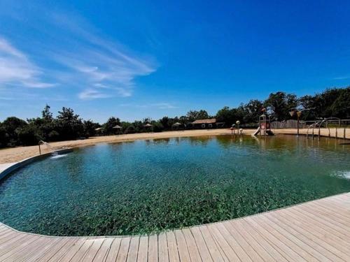 une grande piscine d'eau dans un parc dans l'établissement Chalet 2 chambres au calme avec piscine chauffée, proche lac et plages en Vendée - FR-1-783-20, à La Chapelle-Hermier