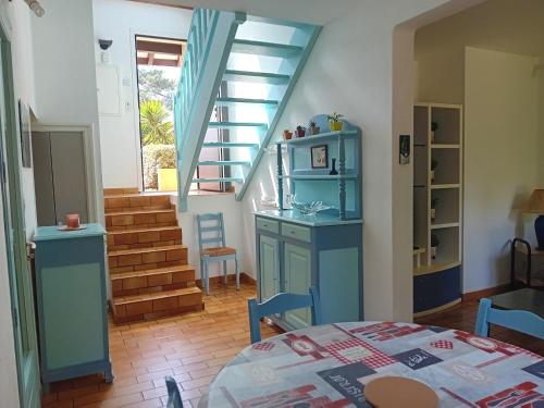 une chambre avec un lit et un escalier avec des armoires bleues dans l'établissement Villa à Seignosse : près forêt et océan, terrasse, parking gratuit - FR-1-239-1129, à Seignosse