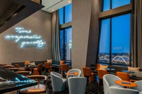a restaurant with chairs and tables and windows at The Joseph, a Luxury Collection Hotel, Nashville in Nashville