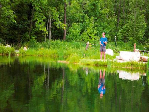 a man standing next to a body of water at Holiday home in Gaal im Murtal in a beautiful setting in Pirkach