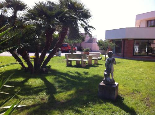 a statue of a girl standing next to a palm tree at Hotel da Filie' in Querceta