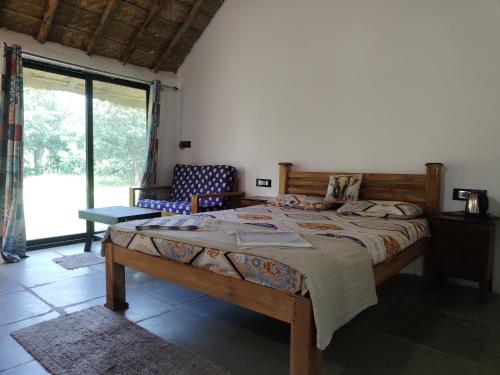 a bedroom with a large bed and a large window at Nyoka Hampi in Hospet
