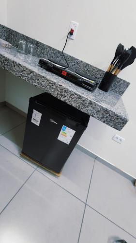 a counter with a box sitting under a counter top at Suítes Caminho do Pantanal in Aquidauana