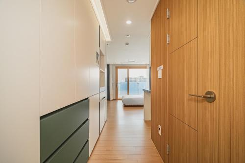 a hallway with a door to a kitchen with a view at Jeju The Terrace View in Jeju
