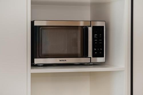 a microwave sitting on a shelf in a kitchen at Jeju The Terrace View in Jeju