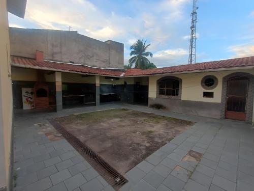 an empty courtyard of a building with a palm tree at Residence Efrata Casa Inteira in Itaboraí