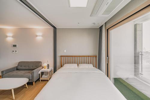 a bedroom with a bed and a couch at Jeju The Terrace View in Jeju