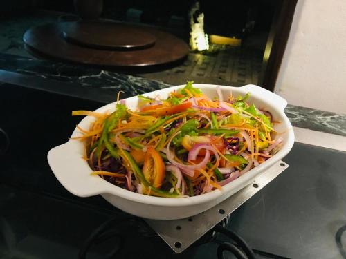 a salad in a white bowl on a table at Hotel Kamrel Sigiriya in Sigiriya