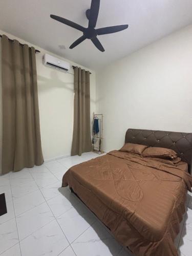 a bedroom with a bed and a ceiling fan at Aisyah Homestay in Kuala Ketil