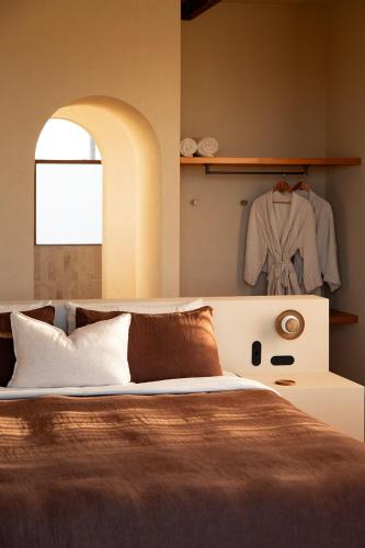 a bedroom with a bed and a clothes rack at Stone - Rare Earth Retreats in McLaren Vale