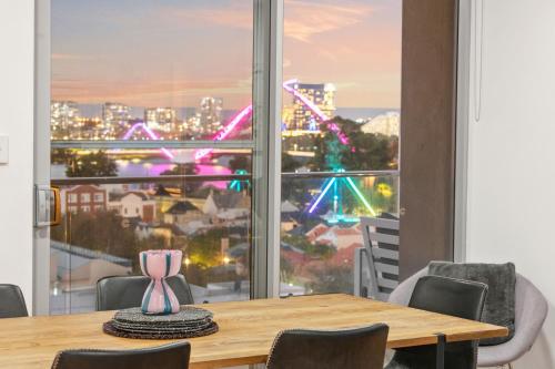 a dining room table with a view of the city at EAST34 - Skyline Haven East Perth in Perth