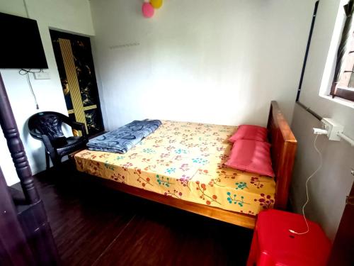 a small bedroom with a bed with colorful sheets at River view Homestay pambar in Kanthalloor