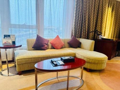 a living room with a couch and a table at Jinhua World Trade Hotel in Jinhua