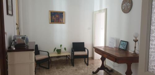 a room with a desk and two chairs and a table at Lyberty in Randazzo