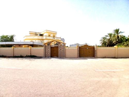 a house with a gate and a fence at Urban Caravanserai - Guest House in Sohar