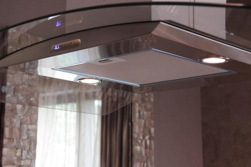 a kitchen hood with a stove top with lights at Villapark Luxury Apartman Balatonfüred in Balatonfüred