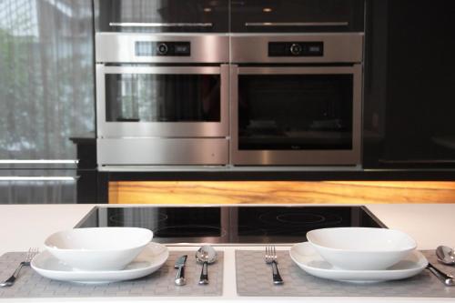 a kitchen with two bowls and a microwave at Villapark Luxury Apartman Balatonfüred in Balatonfüred