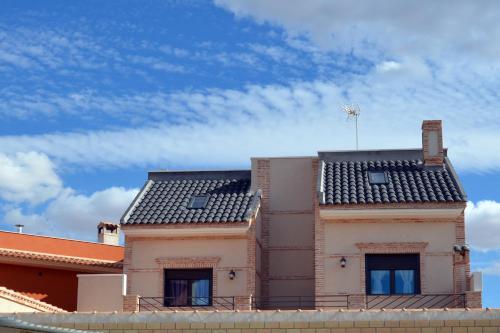 a house with a black roof on top of it at Casa Rural Virgen de las Cruces in Daimiel